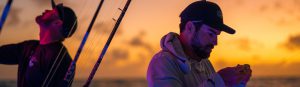 Two men with sunrise in the background preparing for the ultimate Florida sportfishing experience.