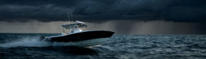 Fiercely-designed Invincible Boat hull design with stormy skies in the background.